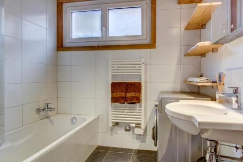 a bathroom with a tub and a sink at Minuit Apartment - Snow and Trek - Morzine in Morzine