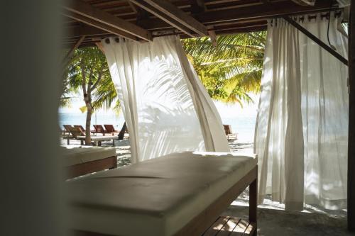 a view of the beach from a resort with white curtains at Long Set Resort in Koh Rong Island