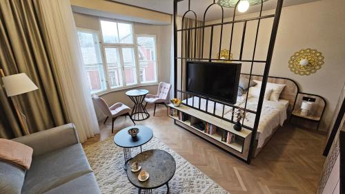 uma sala de estar com uma cama e uma televisão de ecrã plano em Fadilpasic's House em Sarajevo
