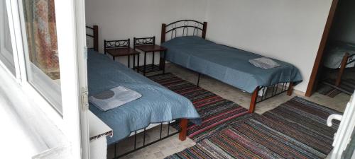 2 camas individuales en una habitación con ventana en Вила Мони-зона релакс, 