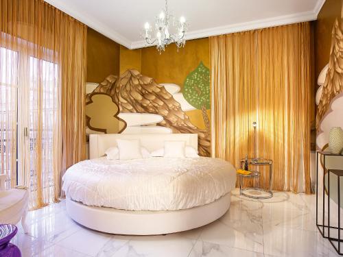 a bedroom with a large white bed in a room at Grecotel Pallas Athena in Athens
