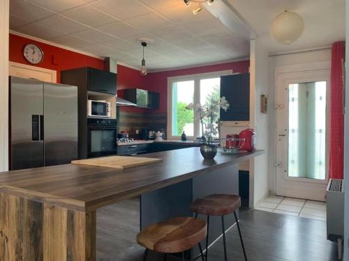 a kitchen with a large wooden island in the middle at Villa de 3 chambres avec piscine chauffée in Villette-dʼAnthon