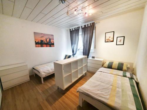 1 dormitorio con 2 camas y ventana en Cozy Apartments in Limeshain, en Hainchen