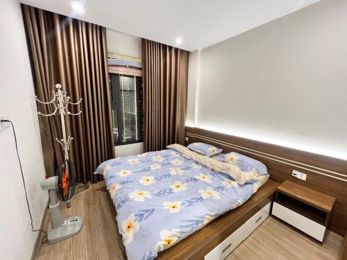 Un dormitorio con una cama con flores. en Skyhome en Gia Lâm Pho