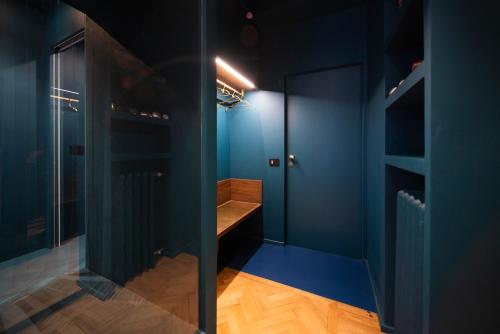 a dressing room with blue walls and a wooden bench at Fontana 16 Rooms in Milan