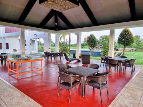 una habitación con mesas y sillas en un suelo rojo en 2B Tiny Home in Iba Zambales en Iba