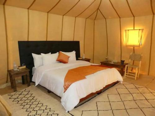 a bedroom with a large bed in a tent at Luxury Desert Camp Merzouga in Merzouga