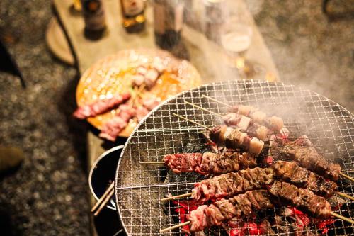 a bunch of skewers on a grill with meat at MOSAIC hinohara in Motojuku