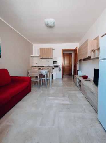 トラーパニにあるScabi Apartmentsの赤いソファとキッチンのあるリビングルーム