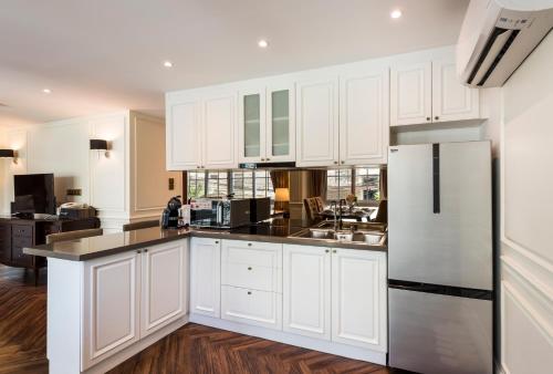 a kitchen with white cabinets and a refrigerator at The Elite @ Thong Lor 25 in Bangkok