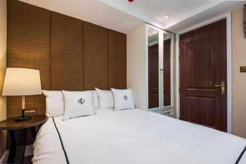 een slaapkamer met een groot wit bed en een lamp bij The Elite @ Thong Lor 25 in Bangkok
