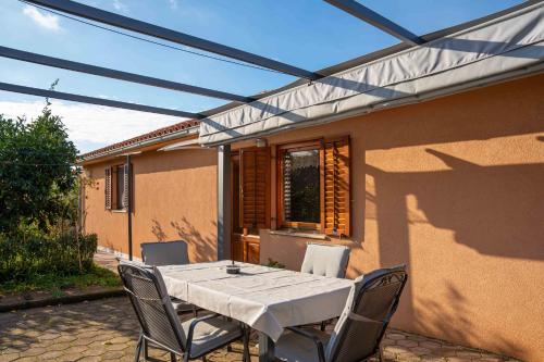 a patio with a white table and chairs at Garden house Kablar in Pula