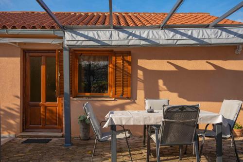 a table and chairs in front of a house at Garden house Kablar in Pula