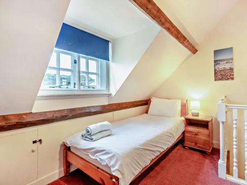Schlafzimmer mit einem Bett und einem Fenster in der Unterkunft 4 Bed in Church Knowle DC125 in Corfe Castle