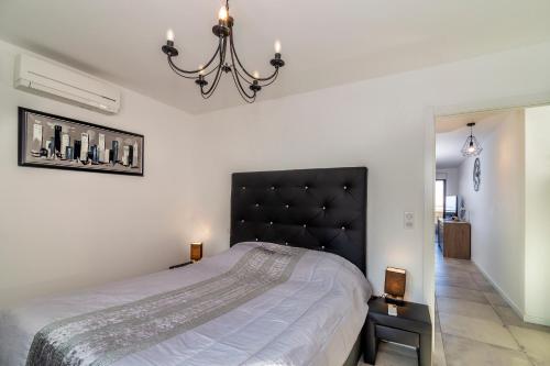 une chambre avec un grand lit avec une tête de lit noire dans l'établissement Les terrasses de l'Isolella, à Porticcio