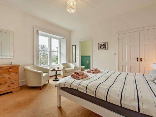 a bedroom with a bed and a chair and a desk at 3 Bed in Tenby 73606 in Tenby