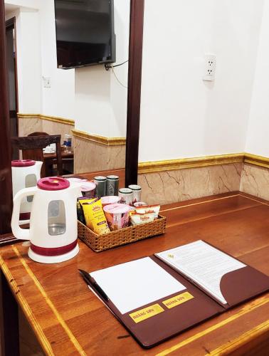 a table with a kettle and a basket of food at Hoang Son Hotel - Can Tho in Can Tho