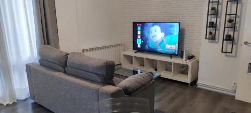 a living room with two chairs and a television at Apartamentos CRISPIN in Corella