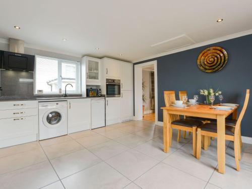 a kitchen and dining room with a table and a washing machine at Lilys Pad in Okehampton