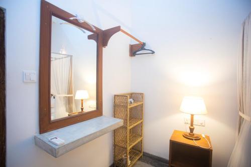 a bathroom with a mirror and a table with a lamp at THE CHILLI STUDIO APARTMENT in Unawatuna
