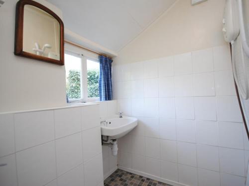 uma casa de banho branca com um lavatório e um espelho em 1 Bed in Burton Bradstock DC016 em Burton Bradstock