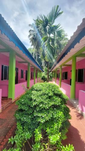 une rangée de maisons avec des toits roses et verts dans l'établissement Dreamland Resort , PORTBLAIR, à Havelock Island