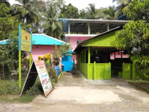 un bâtiment avec un toit vert et un panneau à côté dans l'établissement Dreamland Resort , PORTBLAIR, à Havelock Island