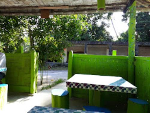 une clôture verte avec une table et des tabourets dans l'établissement Dreamland Resort , PORTBLAIR, à Havelock Island