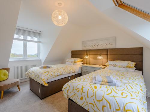 a bedroom with two beds and a chair at 2 Bed in Isle of Purbeck DC118 in Arne