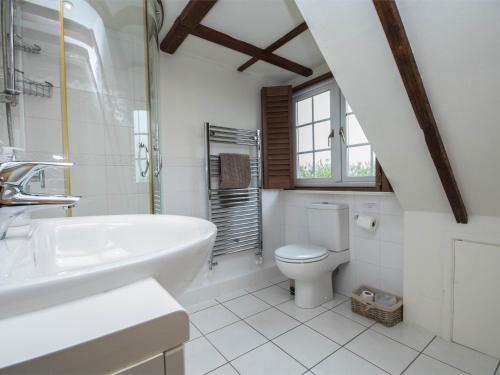 Baño blanco con lavabo y aseo en 4 Bed in Coryates DC041, en Portesham
