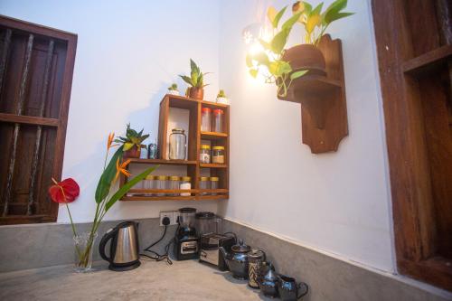 a corner of a kitchen with a counter with flowers on the wall at THE CHILLI STUDIO APARTMENT in Unawatuna