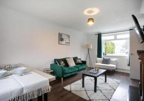 - un salon avec un canapé vert et une table dans l'établissement 3 Bedroom Apartment with non-smoking room - Family & business trip, à Lincolnshire