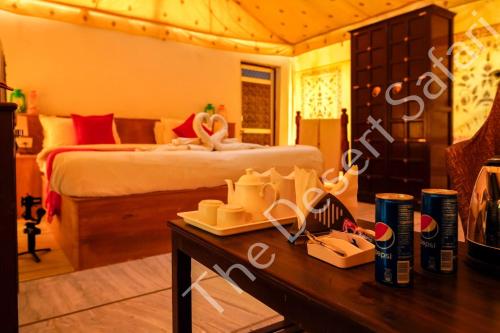 ein Hotelzimmer mit einem Bett und einem Tisch mit einem Tisch in der Unterkunft The Desert Safari Jaisalmer in Sām