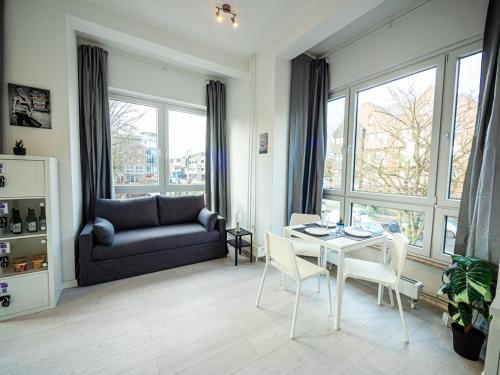 un soggiorno con tavolo, sedie e divano di Work & Stay in Ahrensburg bei Hamburg a Ahrensburg