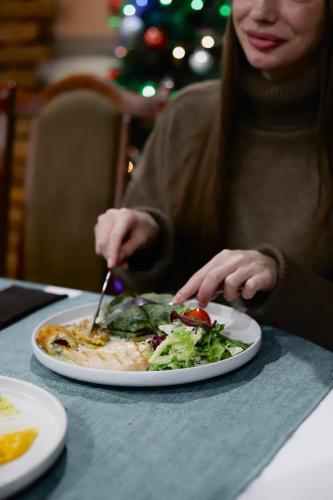 a woman sitting at a table with a plate of food at Vershyna in Dragobrat