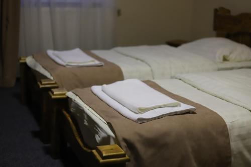 a group of four beds with white towels on them at Vershyna in Dragobrat