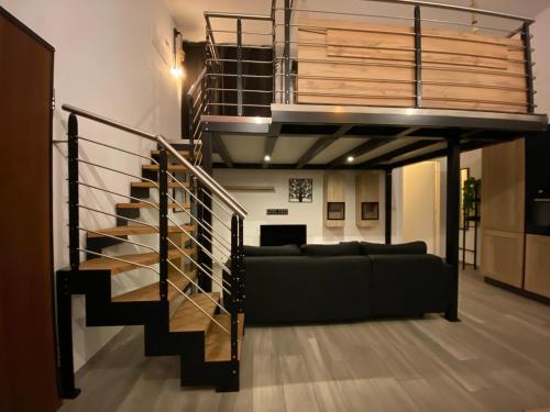 ein Wohnzimmer mit einer Treppe und einer Couch in der Unterkunft Avantgard Rooms Loft Maggiore in Bologna