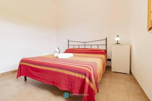 a bedroom with a bed with a red and yellow blanket at Orsetta Flat - Torre Dell'Orso in Torre dell'Orso
