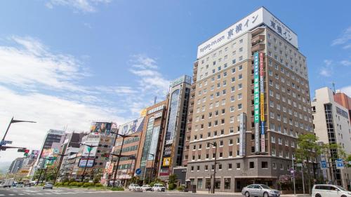 札幌市にある東横INN札幌すすきの交差点の車の通り沿いの高層ビル