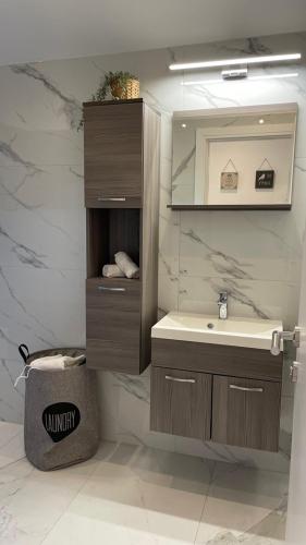 La salle de bains est pourvue d'un lavabo et d'un miroir. dans l'établissement Apartment Julia, à Podgreben