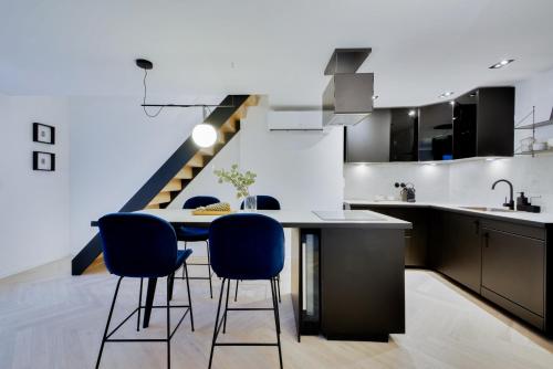une cuisine avec une table et des chaises ainsi qu'un escalier dans l'établissement Le Splendide de Poincaré, à Nancy