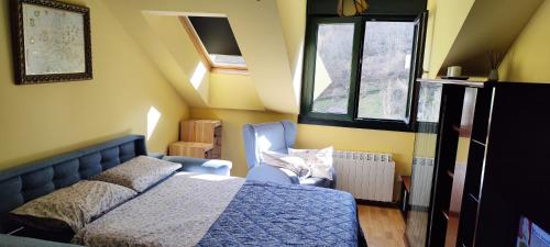 a bedroom with a bed and a chair and windows at Apartamento rural Felechosa in Felechosa