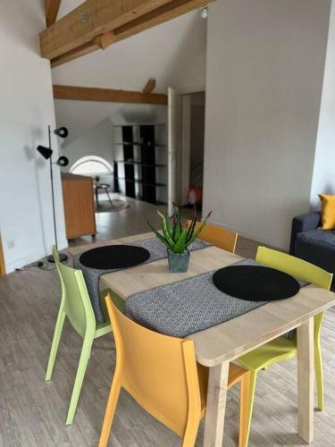 einen Esstisch und Stühle im Wohnzimmer in der Unterkunft Chez Arthur et Zoé. in Stiring-Wendel