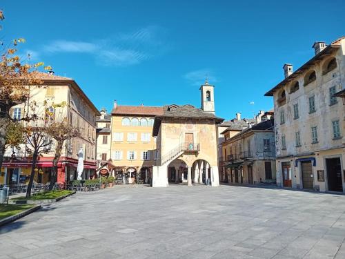 an empty street in a town with a clock tower at Casa Longhi in Orta San Giulio