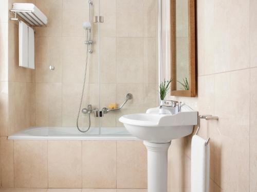 a bathroom with a sink and a shower at Grecotel Pallas Athena in Athens