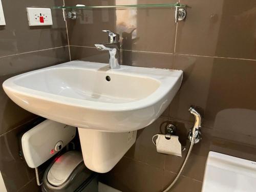a bathroom with a white sink and a toilet at Great 1BR Aqua Livingstone with Netflix, Pool & Gym in Manila