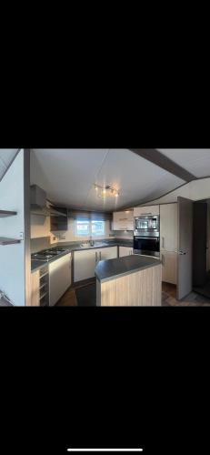 a kitchen with white cabinets and a counter top at Modern caravan Robin Hood Rhyl in Rhyl