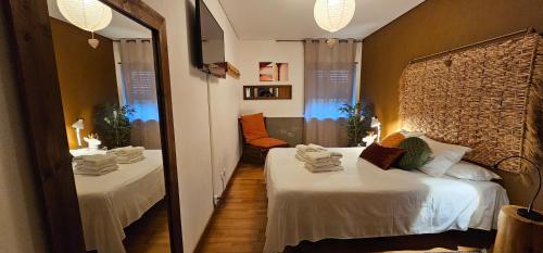 a room with two beds and a mirror at epicenter SANTACRUZ in Lagoa