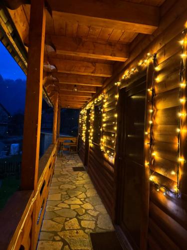 a porch with lights on the side of a house at Guesthouse Prrockaj Theth in Theth