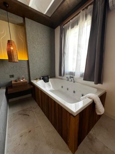 RÜYA BOHEME HOTEL BODRUM في بودروم: حمام مع حوض كبير ونافذة